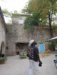 Cour en pierre de La Ferme aux Abeilles avec des ruches colorées et un four à pain traditionnel.