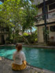 jeune femme assise au bord de la piscine de l hotel outpost ubud bali